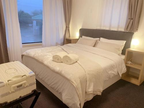 a bedroom with a bed with two towels on it at 10 Angels in Christchurch
