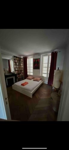 une chambre avec un lit blanc dans une pièce dans l'établissement Superbe 75 m2 deux chambres Paris 5, à Paris