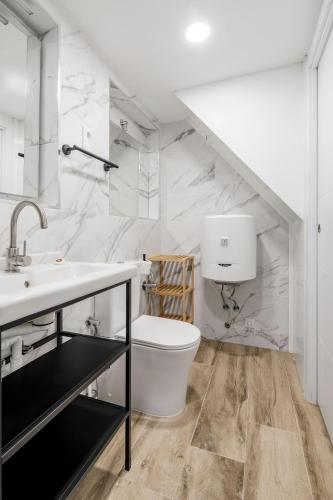 a white bathroom with a sink and a toilet at Madrid Villaverde - Apartamentos acogedores, AC in Madrid