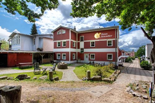 a large red building with a park in front of it at Haus Seeadler Wohnung 10 in Ostseebad Koserow