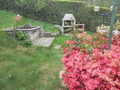 a garden with pink flowers and a fire place at Appartamento a due passi da Burcina in Favaro