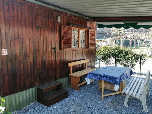 een tafel en een bank buiten een cabine bij Camping Roma in Ventimiglia