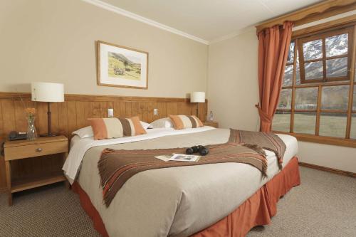 Habitación de hotel con 2 camas y ventana en Hotel Las Torres Patagonia, en Torres del Paine