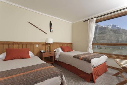 una camera d'albergo con due letti e una finestra di Hotel Las Torres Patagonia a Torres del Paine