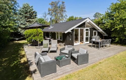 a house with a deck with chairs and a table at Beautiful Home In Odder With Wifi in Odder
