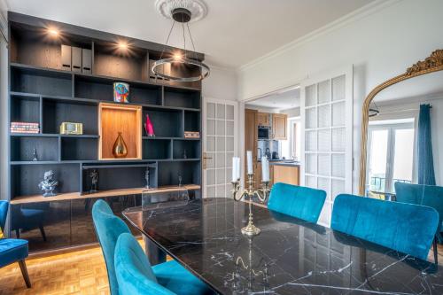 une salle à manger avec une table et des chaises bleues dans l'établissement Le Versailles Suite classé 3 étoiles Vue Château & Potager, à Versailles
