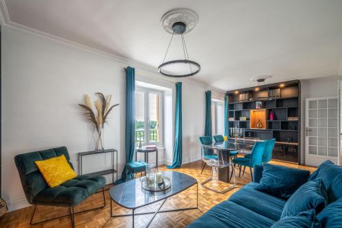 un salon avec un canapé bleu et une table dans l'établissement Le Versailles Suite classé 3 étoiles Vue Château & Potager, à Versailles