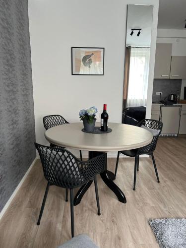 a dining room table with chairs and a bottle of wine at Alpha Rooms in Backnang