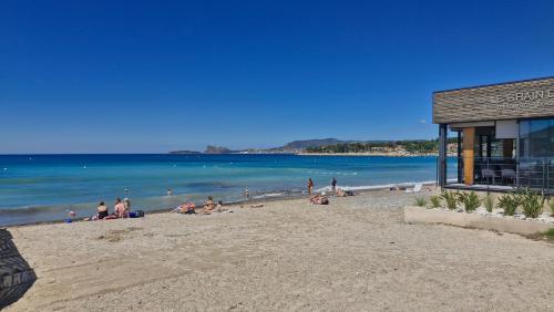 a group of people sitting on a beach at Maison familiale Jardin parking, 10 min plage, 1* in Saint-Cyr-sur-Mer