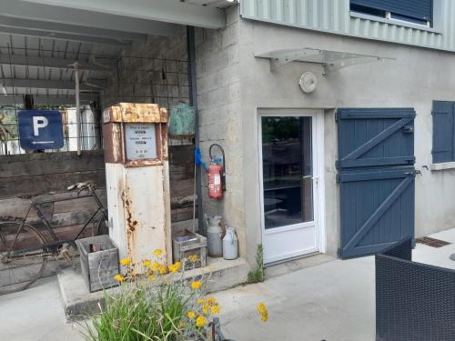 un vieux bâtiment avec une porte bleue et un portail dans l'établissement Le Dépôt, à Rochetoirin