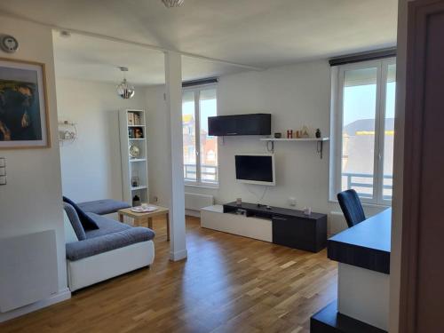 un salon avec un canapé et une télévision dans l'établissement Appartement vue mer à 100 m de la plage, à Ault