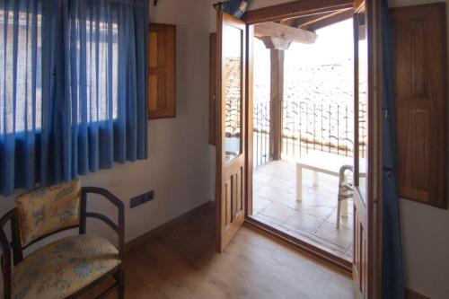 a room with a door to a balcony with a view of a patio at Hospedium Hotel Rural Abadía de Yuste in Cuacos de Yuste
