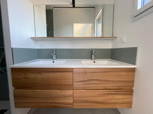 a bathroom with a sink and a mirror at Maison 5 chambres sortie saint malo in Saint-Méloir-des-Ondes