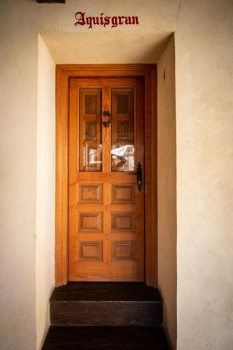 a wooden door in a building with a sign on it at Hospedium Hotel Rural Abadía de Yuste in Cuacos de Yuste