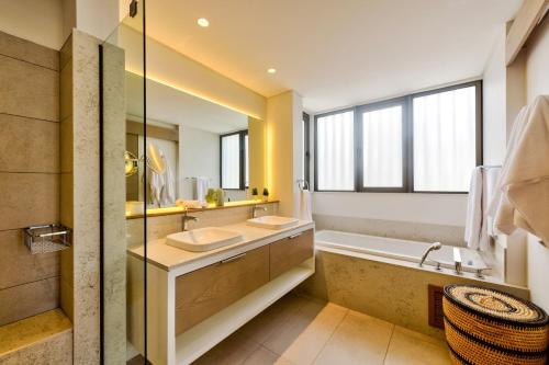 モン・ショワジーにあるMauritius Ultra Luxury Apartmentの洗面台2つとバスタブ付きのバスルーム