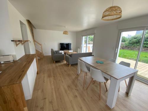une cuisine et un salon avec une table et des chaises dans l'établissement Maison bord de mer à Etel, à Étel