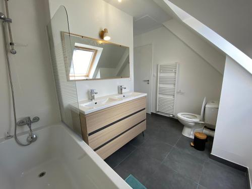 une salle de bain avec un lavabo et des toilettes dans l'établissement Maison bord de mer à Etel, à Étel