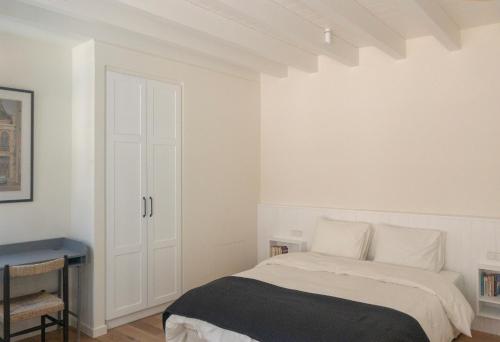 a white bedroom with a bed and a desk at Bigtrel Athens in Athens