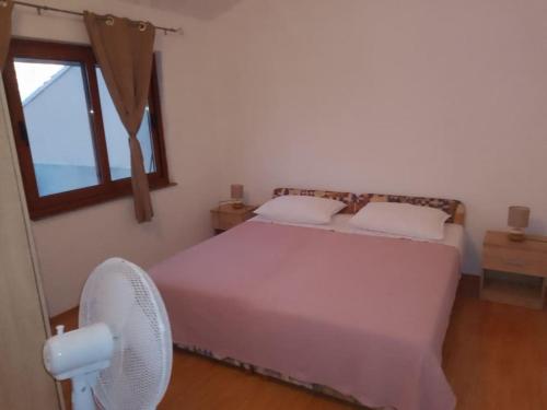 a bedroom with a bed with a fan and a window at Sea and Sun Pakoštane in Pakoštane