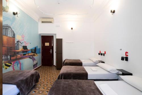 a room with three beds in a room at Home Youth Hostel by Feetup Hostels in Valencia