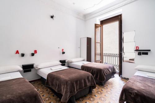 a room with three beds and a balcony at Home Youth Hostel by Feetup Hostels in Valencia