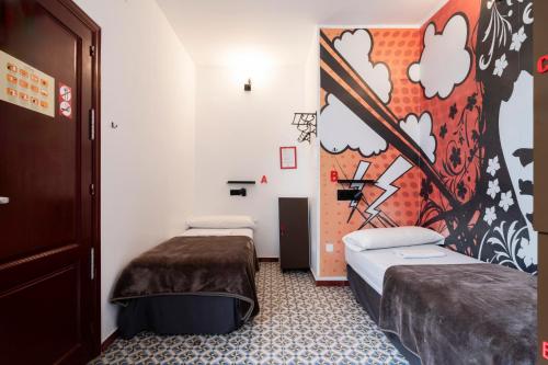 two beds in a room with a painting on the wall at Home Youth Hostel by Feetup Hostels in Valencia