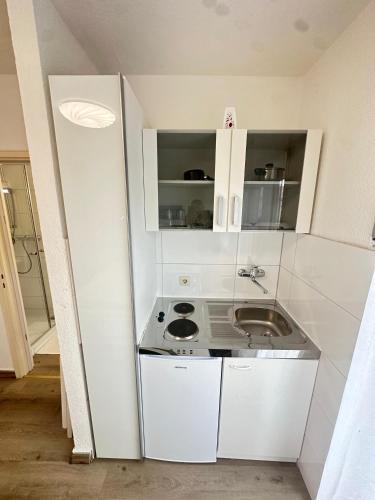 a kitchen with white cabinets and a sink at Tolle FeWo direkt am Campus 24-7 Checkin in Germersheim