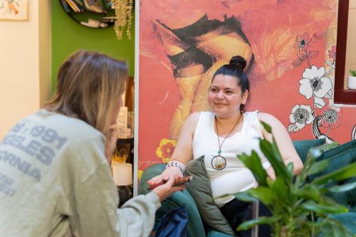a woman talking to a woman sitting in a chair at Home Youth Hostel by Feetup Hostels in Valencia