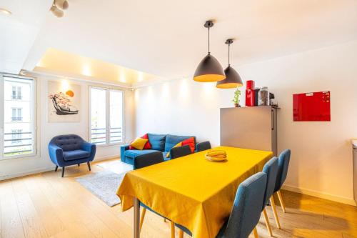 - un salon avec une table et des chaises jaunes dans l'établissement GuestReady - Colourful Getaway near Eiffel Tower, à Paris