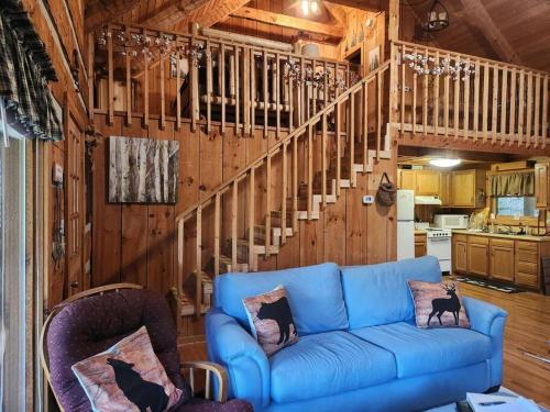 un soggiorno con un divano blu e una scala di MoonPie Hideaway a Sevierville