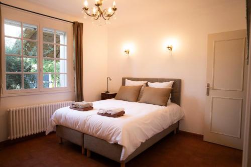 une chambre avec un lit avec deux serviettes dessus dans l'établissement La maison de Juliette - climatisée, à Charleval