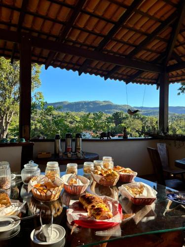 a table with many bowls of food on it with a view at Pousada Rio das Almas in Pirenópolis