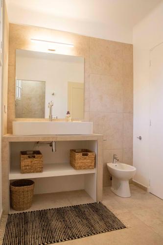 une salle de bain avec un lavabo et un miroir et des toilettes dans l'établissement La maison de Juliette - climatisée, à Charleval