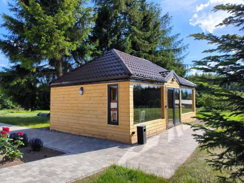 ein kleiner Schuppen mit Dach auf einer Terrasse in der Unterkunft Przystań Jeziorany - domki na mazurach in Jeziorany