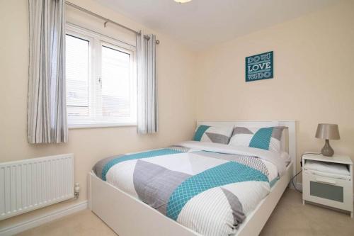 a bedroom with a bed and a window in it at Quiet Two Bedroom House Driveway Parking & Garden in Wolverhampton