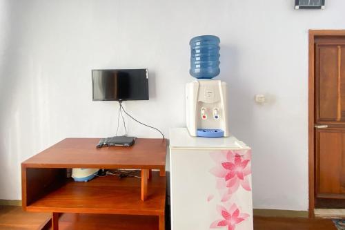 a blender sitting on top of a refrigerator next to a table at Ayi The Costel Syariah Bengkulu Mitra RedDoorz in Curup