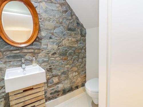 bagno con lavandino bianco e parete in pietra di Wee Cottage a Moffat
