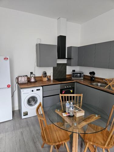 a kitchen with a glass table and chairs in a kitchen at Kingdom apartments in Wolverhampton