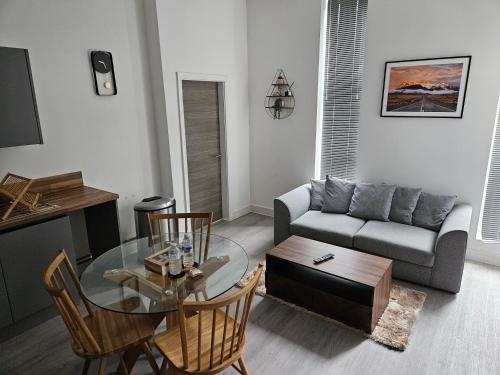 a living room with a glass table and a couch at Kingdom apartments in Wolverhampton