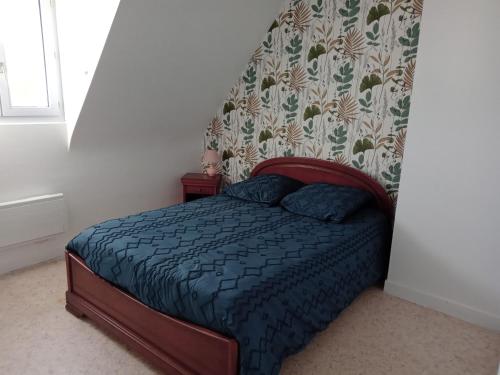 une chambre avec un lit avec une couette bleue dans l'établissement Maison Pays Fouesnantais