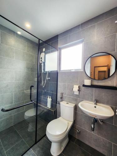 a bathroom with a toilet and a sink and a mirror at Ayera Residence Muji X Near Permas X Staycation 4BR4B #12 pax by Cowidea in Masai