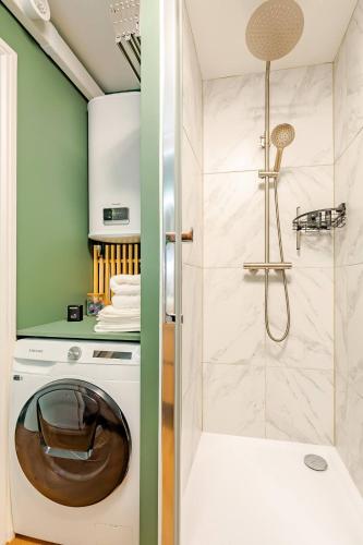 La salle de bains est pourvue d'un lave-linge et d'une douche. dans l'établissement SMART Studio ultra connecté - Escale parfaite entre Disneyland et Paris, à Noisy-le-Grand