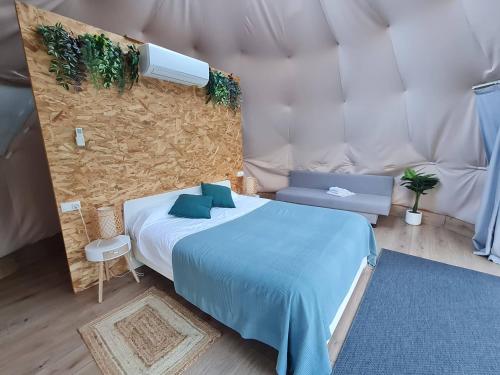 a bedroom with a bed and a wall with plants at Glamping Cañon del Rio Lobos in Ucero