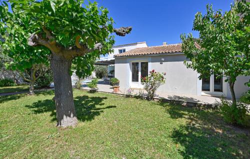 a white house with a tree in the yard at 3 Bedroom Beautiful Home In Remoulins in Remoulins