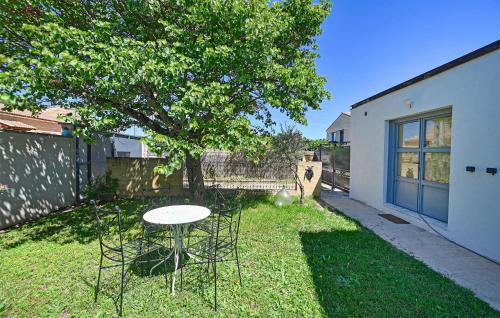 a table and chairs in a yard with a tree at 3 Bedroom Beautiful Home In Remoulins in Remoulins