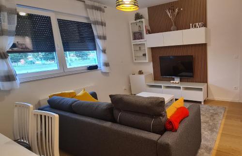 a living room with a couch and a television at RingPeace Apartment, Dubrava - free parking in Zagreb