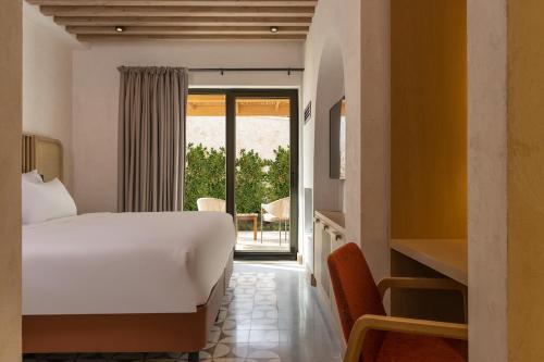 a bedroom with a white bed and a balcony at Radisson Blu Hotel, Kas in Kas