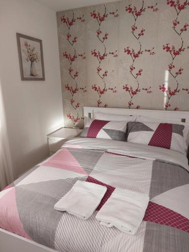 a bedroom with a bed with pink and white blankets at Spacious 4 Bed house with parking and garden at Reading in Reading