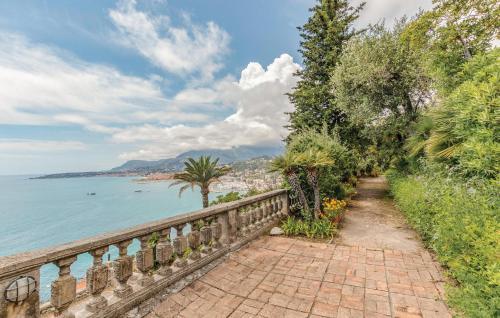 a brick walkway next to the water with trees at 1 Bedroom Lovely Apartment In Grimaldi in Grimaldi