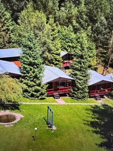 an aerial view of a building with trees and grass at Domki letniskowe pod Brzozami Stella in Polańczyk
